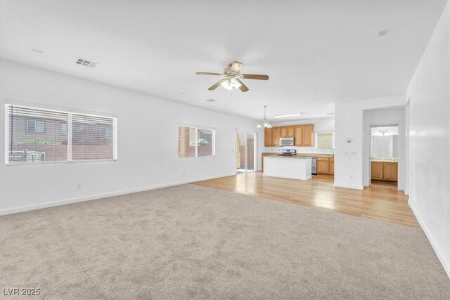 5060 Blue Rose St, North Las Vegas, NV 89081 - unfurnished living room featuring visible vents, a ceiling fan, baseboards, and light carpet