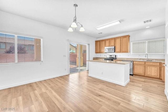 5060 Blue Rose St, North Las Vegas, NV 89081 - kitchen featuring light wood finished floors, stainless steel appliances, light countertops, visible vents, and a chandelier