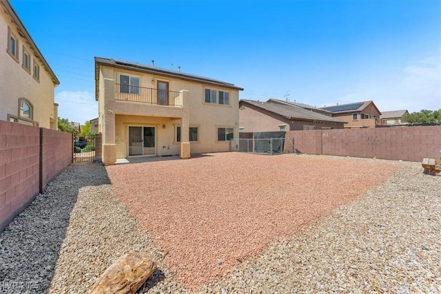 5060 Blue Rose St, North Las Vegas, NV 89081 - back of property with roof mounted solar panels, a gate, a fenced backyard, a balcony, and stucco siding