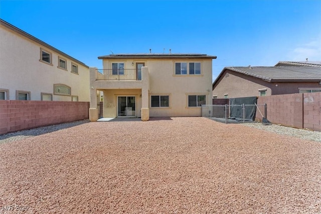 5060 Blue Rose St, North Las Vegas, NV 89081 - rear view of house featuring a gate, a balcony, a fenced backyard, and stucco siding