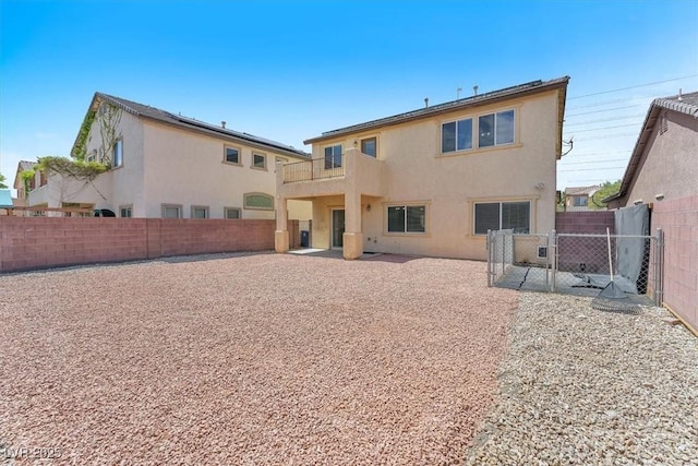5060 Blue Rose St, North Las Vegas, NV 89081 - rear view of property featuring stucco siding, a gate, a balcony, and a fenced backyard