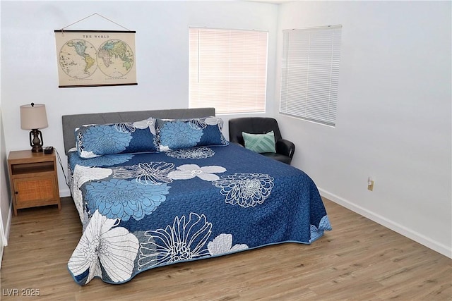 bedroom with baseboards and wood finished floors