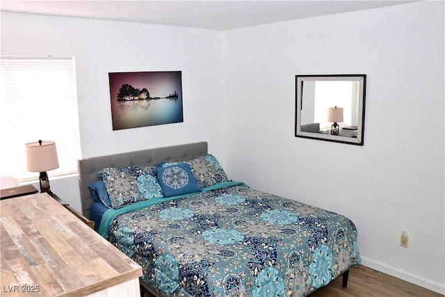bedroom featuring baseboards and wood finished floors