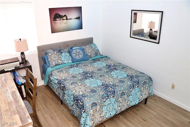 bedroom with baseboards and wood finished floors