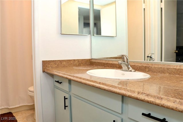 bathroom featuring toilet, vanity, and tile patterned floors