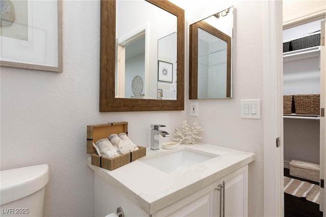 half bathroom featuring vanity and toilet