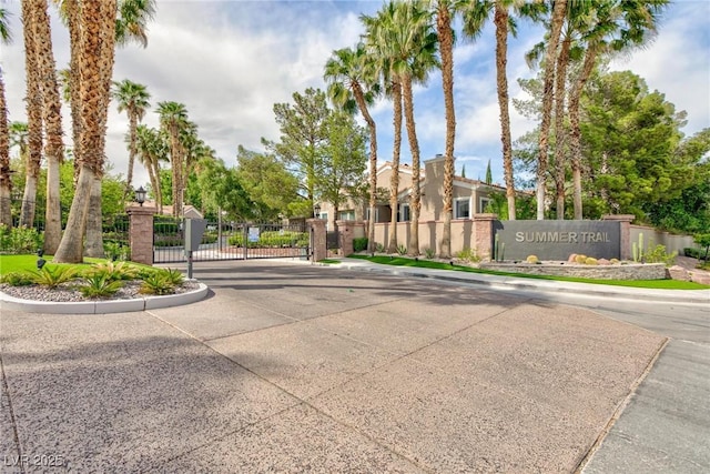 view of road featuring a gate, a gated entry, and curbs