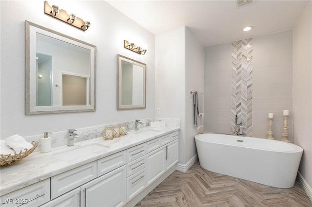 full bathroom featuring baseboards, a sink, and double vanity