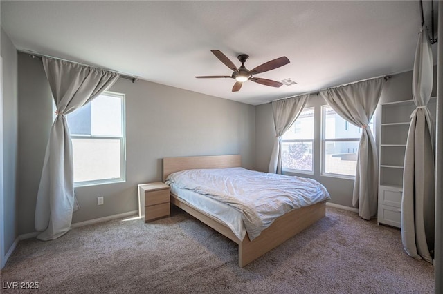 carpeted bedroom featuring baseboards, a ceiling fan, visible vents, and multiple windows