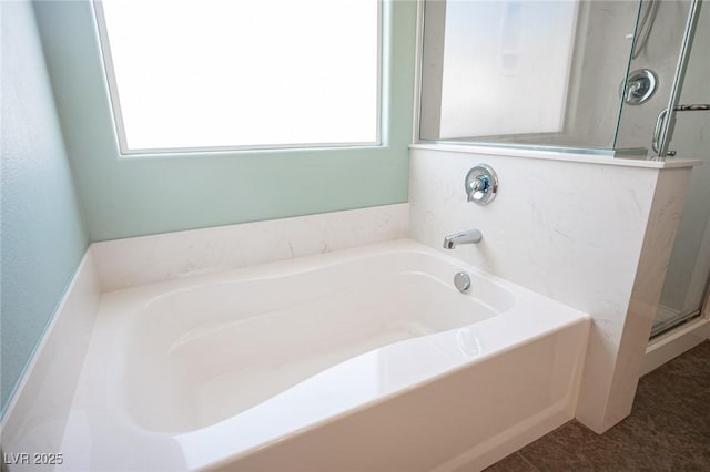 bathroom with plenty of natural light, a garden tub, and a stall shower
