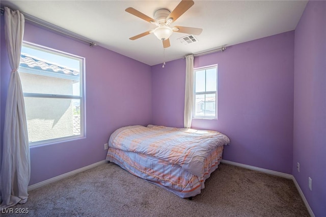 carpeted bedroom featuring baseboards, a ceiling fan, and visible vents