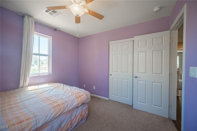bedroom with baseboards, visible vents, a ceiling fan, a closet, and carpet floors