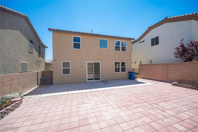 back of property with a patio area, central AC unit, a fenced backyard, and stucco siding