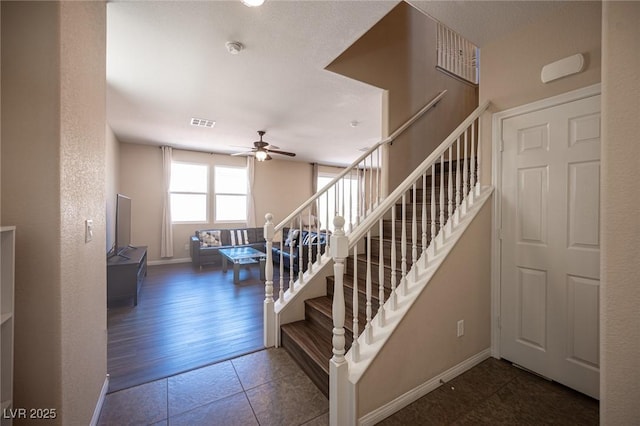 staircase featuring baseboards, a ceiling fan, tile patterned flooring, and visible vents
