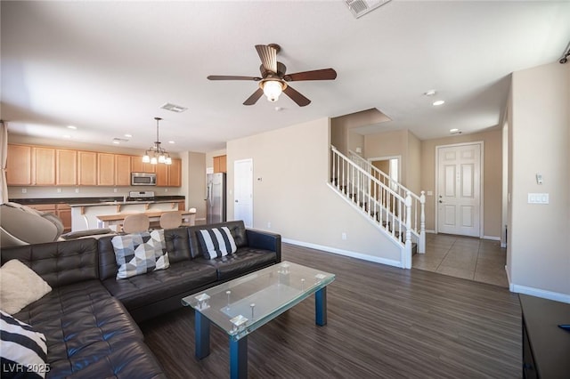living area with recessed lighting, baseboards, visible vents, and stairs