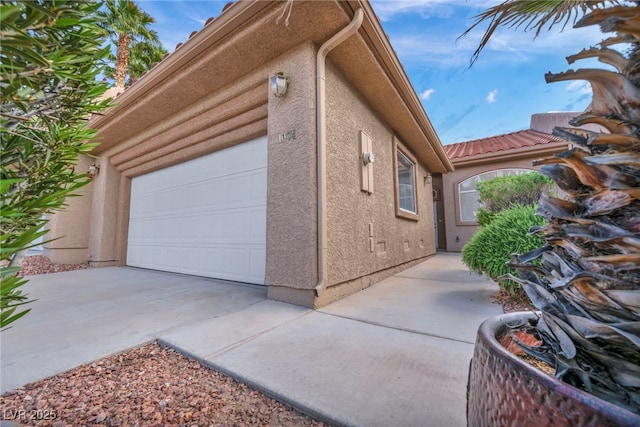 1074 Chaparral Dr, Mesquite, NV 89027 - view of side of property with concrete driveway, stucco siding, and an attached garage