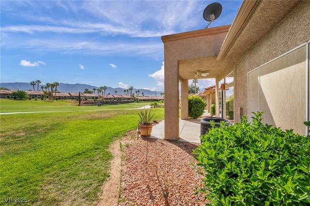 1074 Chaparral Dr, Mesquite, NV 89027 - view of grassy yard featuring a mountain view, a patio, a ceiling fan, and golf course view
