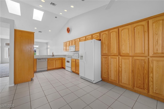 1074 Chaparral Dr, Mesquite, NV 89027 - kitchen featuring white appliances, a skylight, light countertops, light tile patterned flooring, and high vaulted ceiling