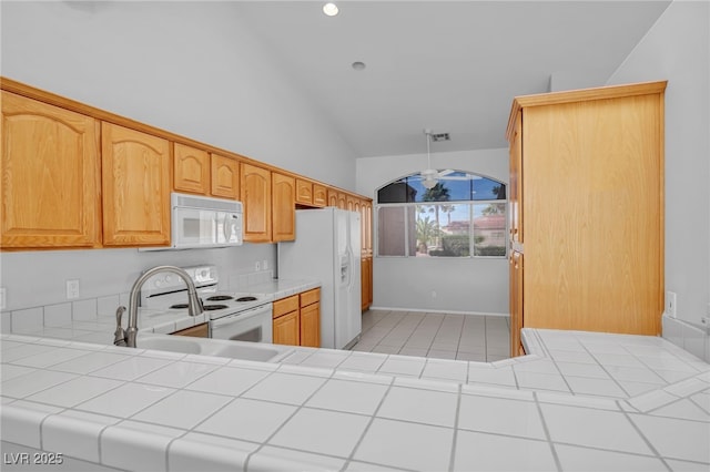 1074 Chaparral Dr, Mesquite, NV 89027 - kitchen featuring white appliances, vaulted ceiling, tile countertops, recessed lighting, and light tile patterned floors