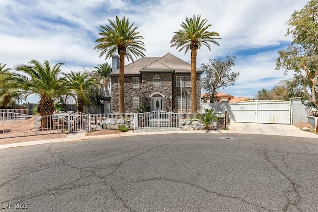 6520 Turtle Hill Rd, Las Vegas, NV 89110 - view of front of house with a gate, stone siding, a tiled roof, and fence private yard