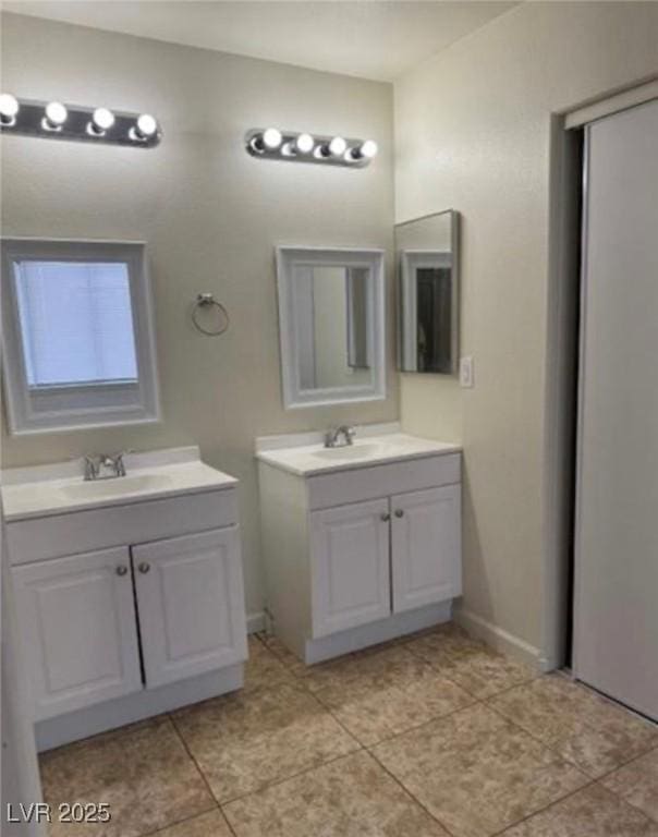 1003 Dover Glen Dr, North Las Vegas, NV 89031 - full bath with two vanities, tile patterned flooring, a sink, and baseboards