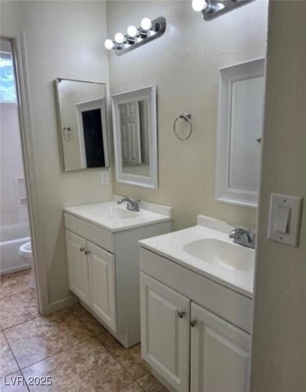 1003 Dover Glen Dr, North Las Vegas, NV 89031 - bathroom featuring two vanities, toilet, and a sink