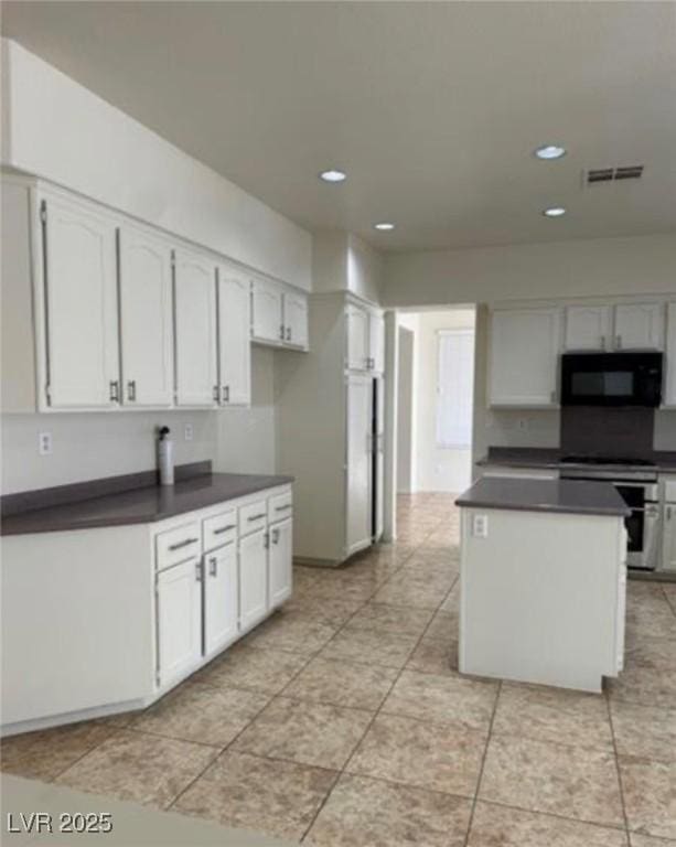 1003 Dover Glen Dr, North Las Vegas, NV 89031 - kitchen with recessed lighting, dark countertops, visible vents, black microwave, and stainless steel range oven