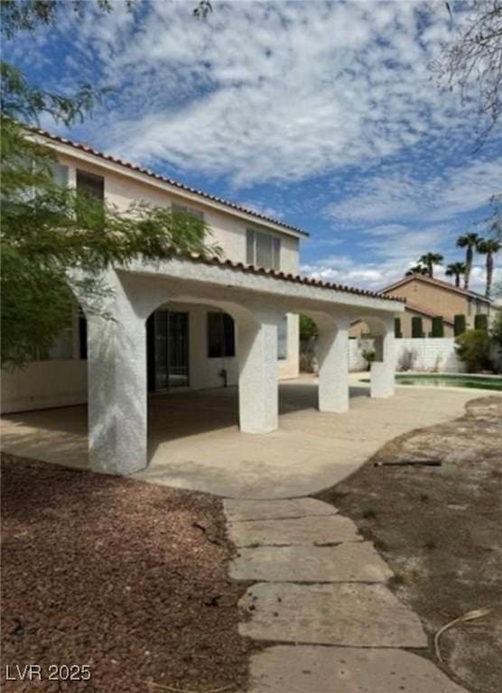 1003 Dover Glen Dr, North Las Vegas, NV 89031 - back of house featuring a tiled roof, a patio, and stucco siding