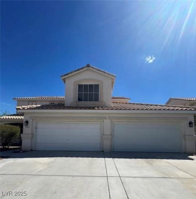 1003 Dover Glen Dr, North Las Vegas, NV 89031 - mediterranean / spanish home with concrete driveway, a garage, a tiled roof, and stucco siding
