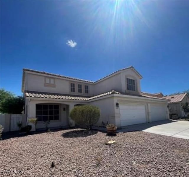 1003 Dover Glen Dr, North Las Vegas, NV 89031 - view of front facade with a tiled roof, driveway, fence, a garage, and stucco siding