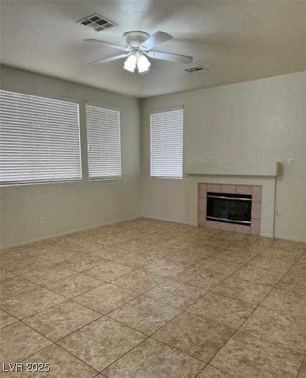 1003 Dover Glen Dr, North Las Vegas, NV 89031 - unfurnished living room with ceiling fan, tile patterned flooring, a tile fireplace, and visible vents