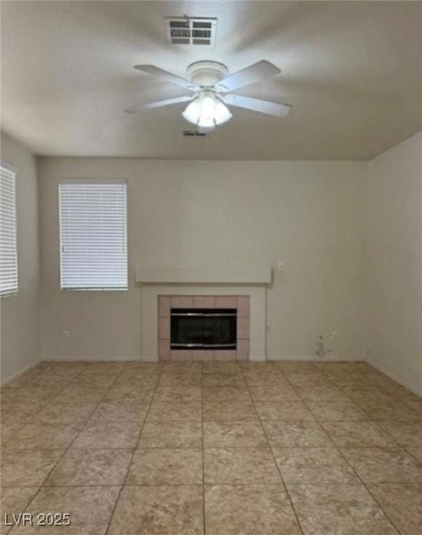 1003 Dover Glen Dr, North Las Vegas, NV 89031 - unfurnished living room featuring a tile fireplace, visible vents, a wealth of natural light, and ceiling fan