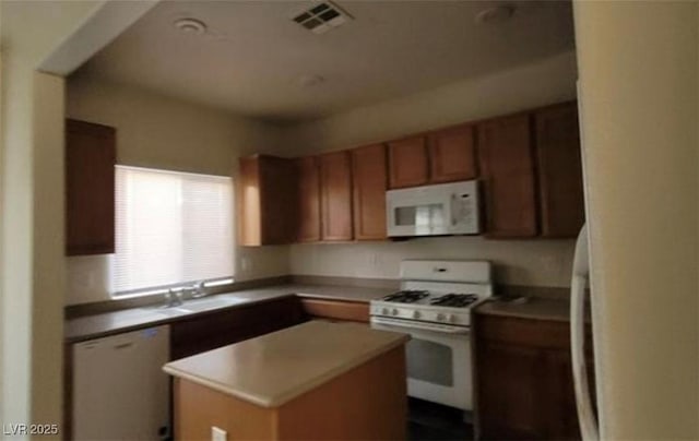 8768 Charm Canyon Ave, Las Vegas, NV 89178 - kitchen with a sink, visible vents, white appliances, light countertops, and a kitchen island
