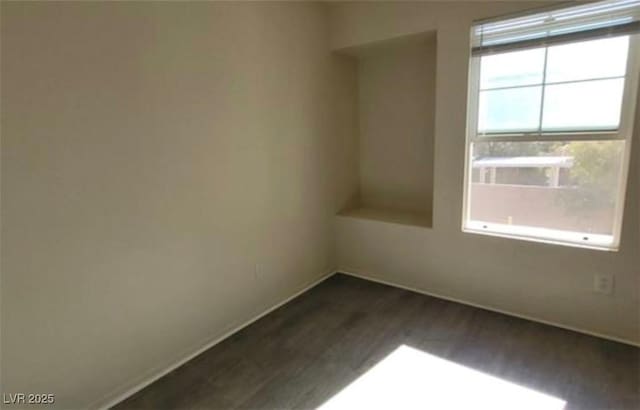 8768 Charm Canyon Ave, Las Vegas, NV 89178 - unfurnished room with baseboards and dark wood-style floors