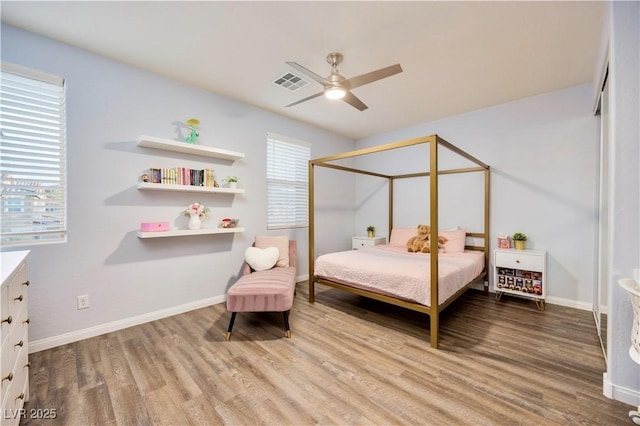 bedroom featuring wood finished floors, visible vents, and baseboards