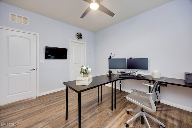 office featuring wood finished floors, visible vents, a ceiling fan, and baseboards