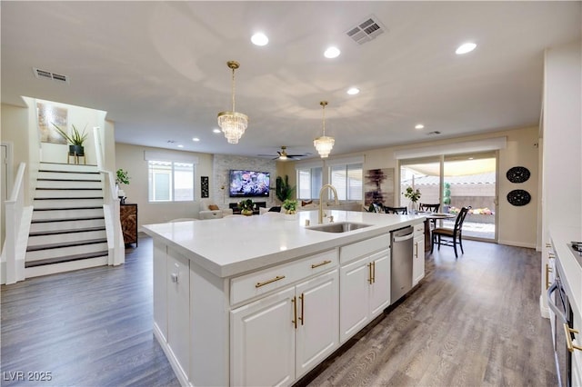 kitchen featuring open floor plan, wood finished floors, visible vents, and a sink