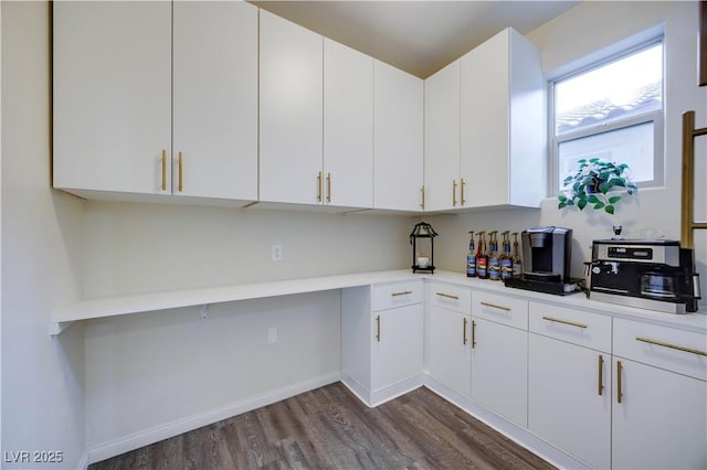 kitchen featuring white cabinets, light countertops, baseboards, and dark wood-type flooring