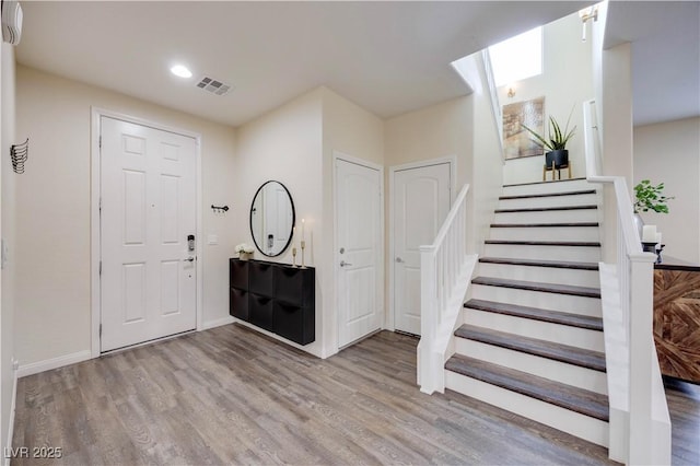 entryway featuring visible vents, wood finished floors, recessed lighting, and stairs