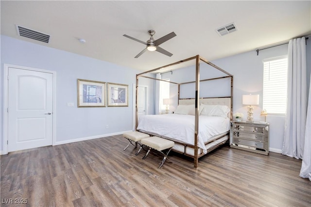 bedroom featuring baseboards, wood finished floors, and visible vents