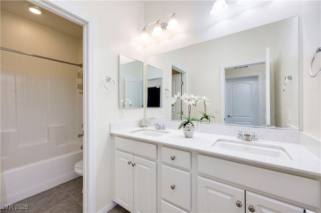 full bath featuring tile patterned floors, a sink, double vanity, and toilet