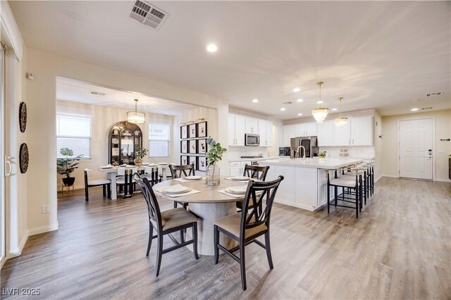 dining space with recessed lighting, light wood-style flooring, visible vents, and baseboards