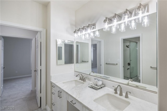 bathroom featuring an inviting chandelier, double vanity, a stall shower, and a sink