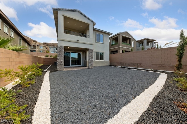 31 Strada Loreto, Henderson, NV 89011 - rear view of property featuring a fenced backyard, a patio, a balcony, and stucco siding
