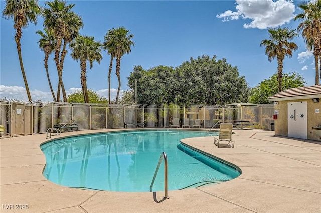 community pool with fence and a patio