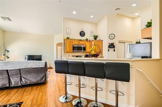 kitchen featuring stainless steel appliances, a kitchen breakfast bar, and visible vents