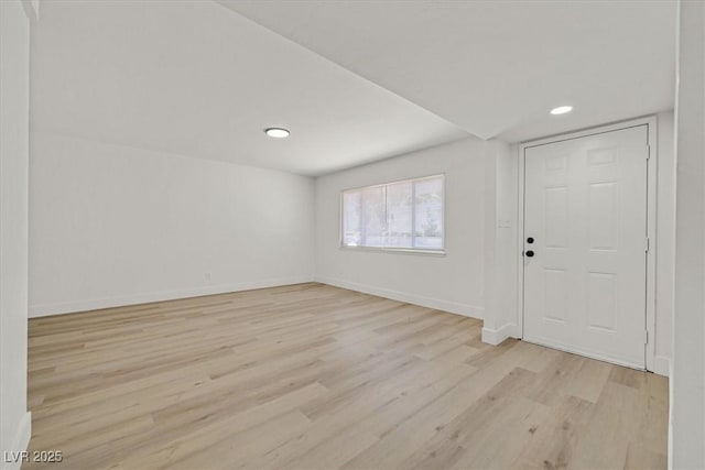 interior space with baseboards, light wood finished floors, and recessed lighting
