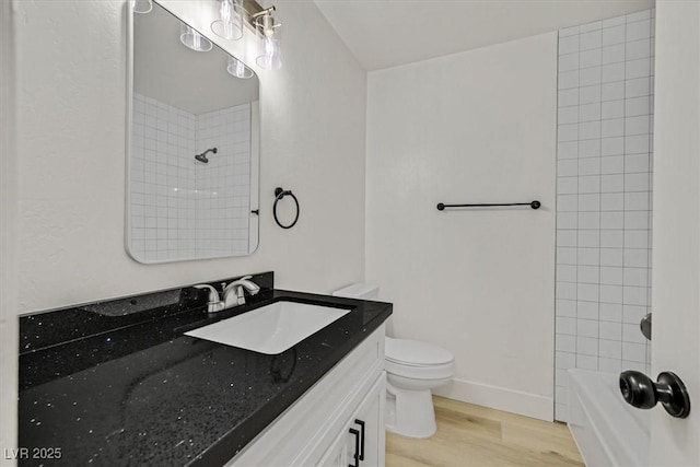 full bath with baseboards, wood finished floors, toilet, and vanity