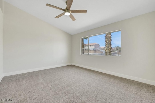 carpeted empty room with vaulted ceiling, baseboards, and ceiling fan