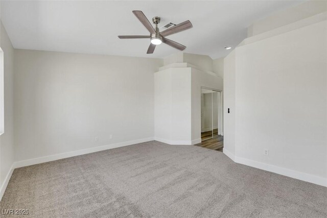 carpeted spare room featuring ceiling fan, baseboards, lofted ceiling, and visible vents
